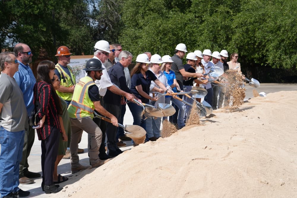 People breaking ground with shovels 
