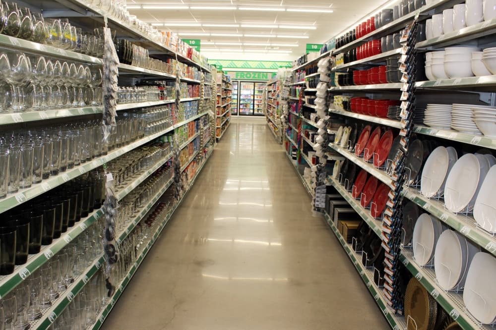 Store aisle with glasses and dishes on shelves. 