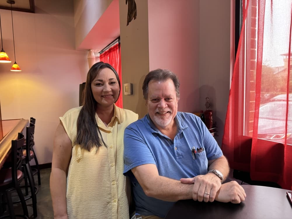 Two people standing in a restaurant. 