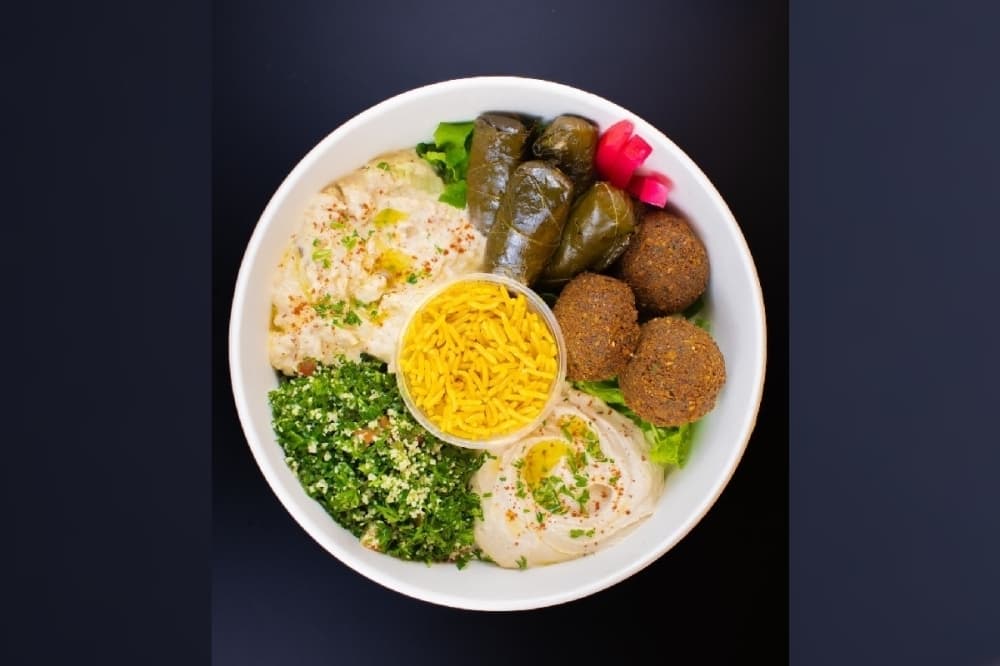 Overview photo of rice, dolmades and other items in a bowl. 