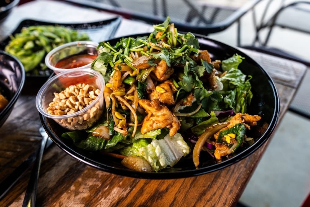 Overview of various proteins, vegetables and sauces in a bowl. 