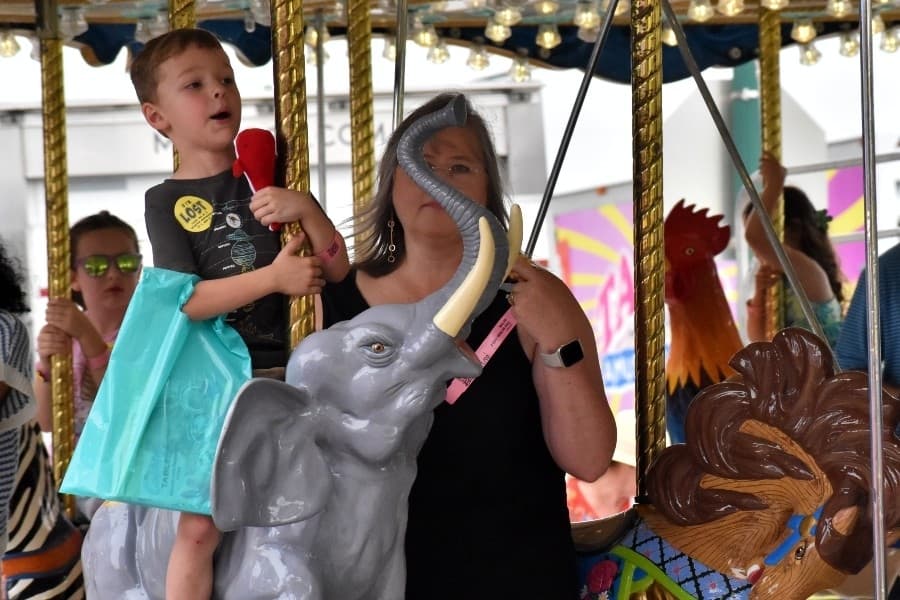 child riding a carnival 