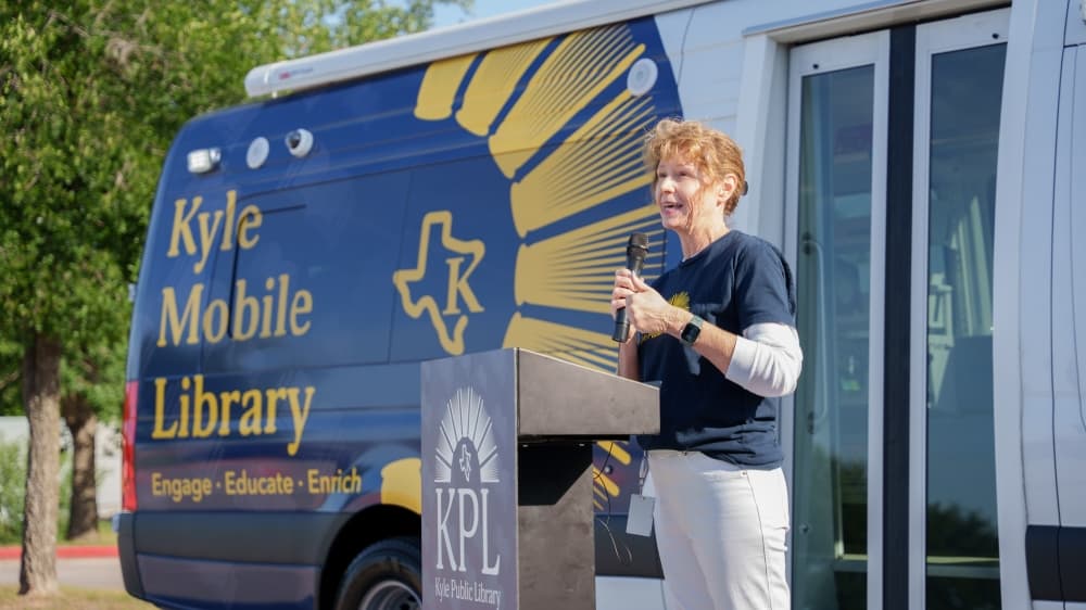 Someone speaking in front of the mobile library 