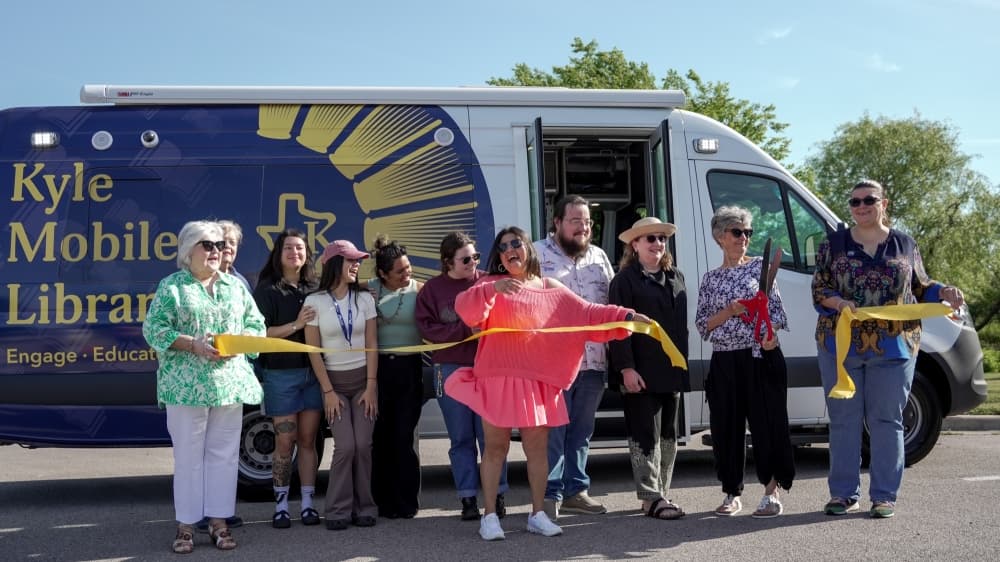 People cutting a ribbon in front of the mobile library