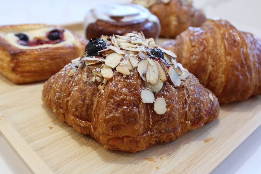 Tray of baked items featuring a berry almond croissant. 