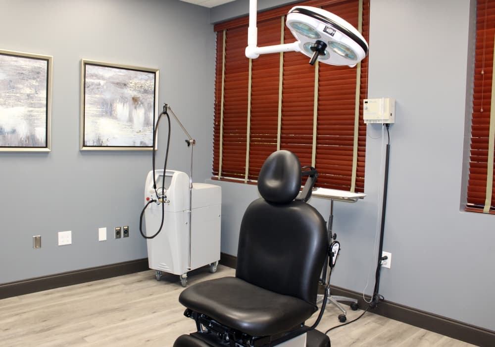 Medical procedure room with medical examination chair and ceiling adjustable light. 