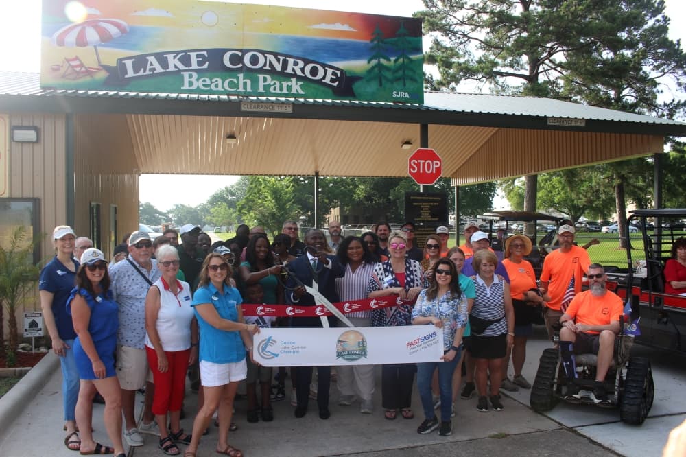 The Herbert family joined with members of the San Jacinto River Authority and the Lake Conroe Chamber of Commerce for a ribbon cutting of the Lake Conroe Beach Park on May 24. (Jessica Shorten/Community Impact)
