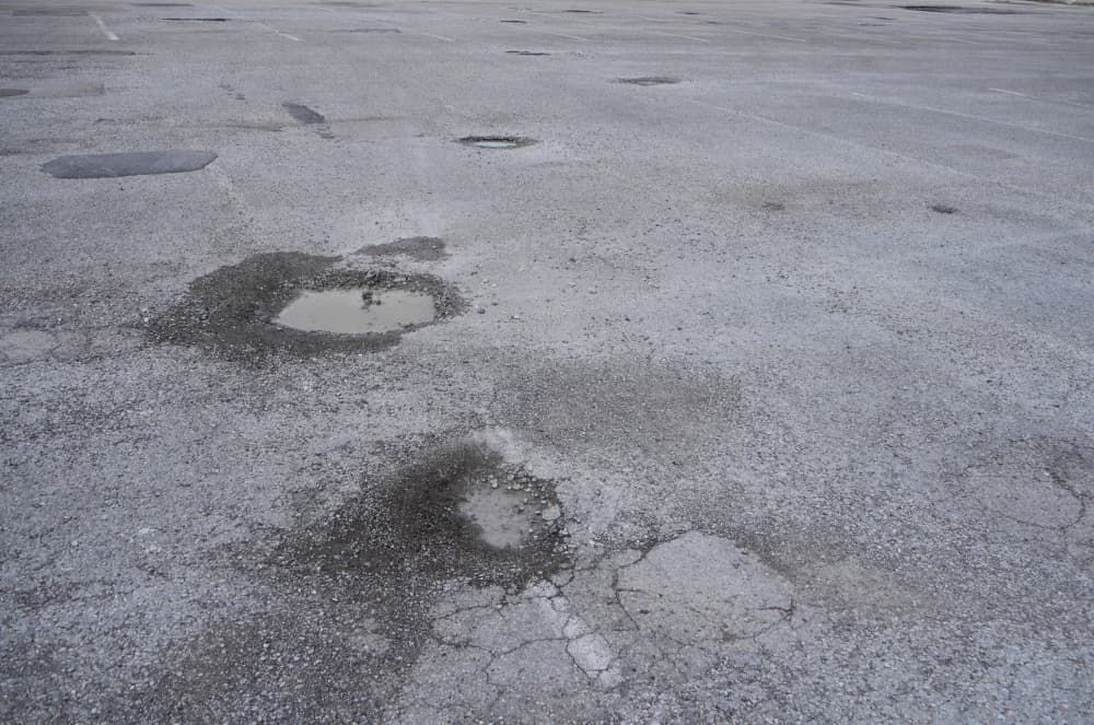 Several potholes littered through Clark Stadium's parking lot. 