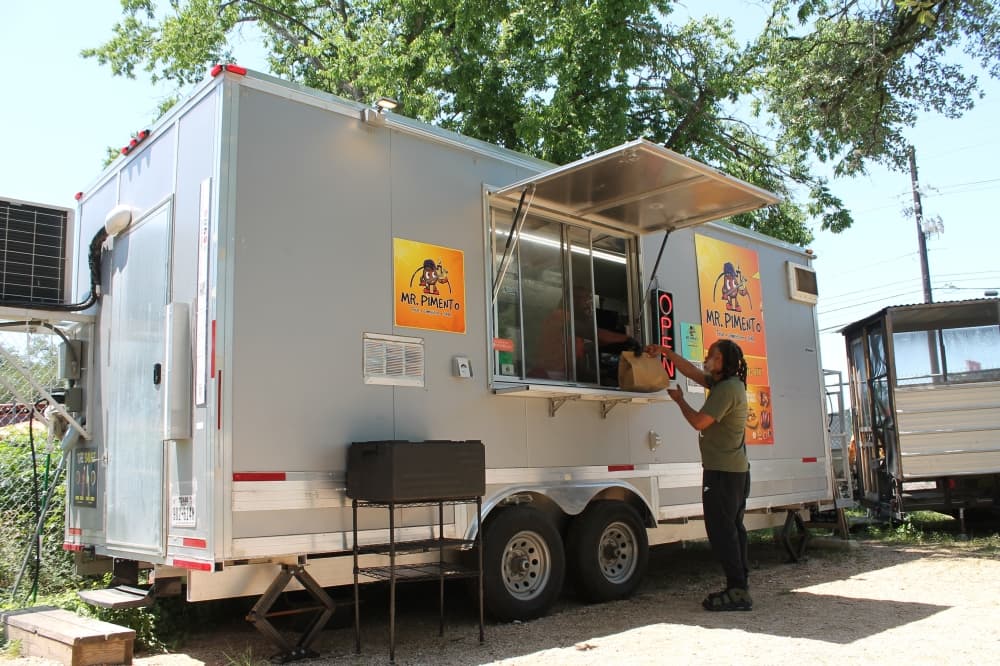 Customer receiving food from Mr. Pimento food truck