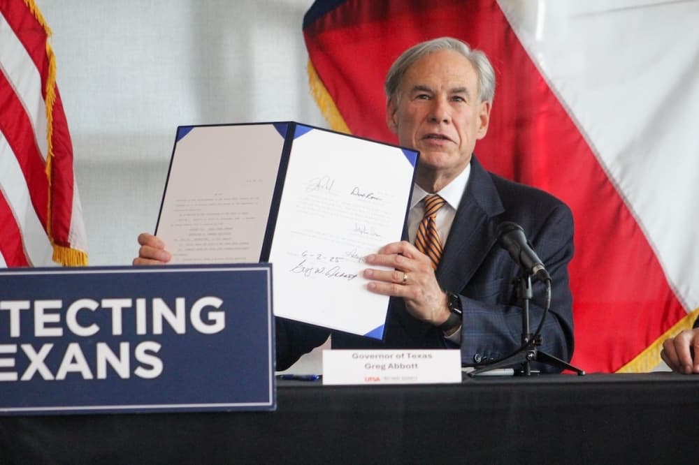 Texas Gov. Greg Abbott is seen holding a bill he just signed into law.