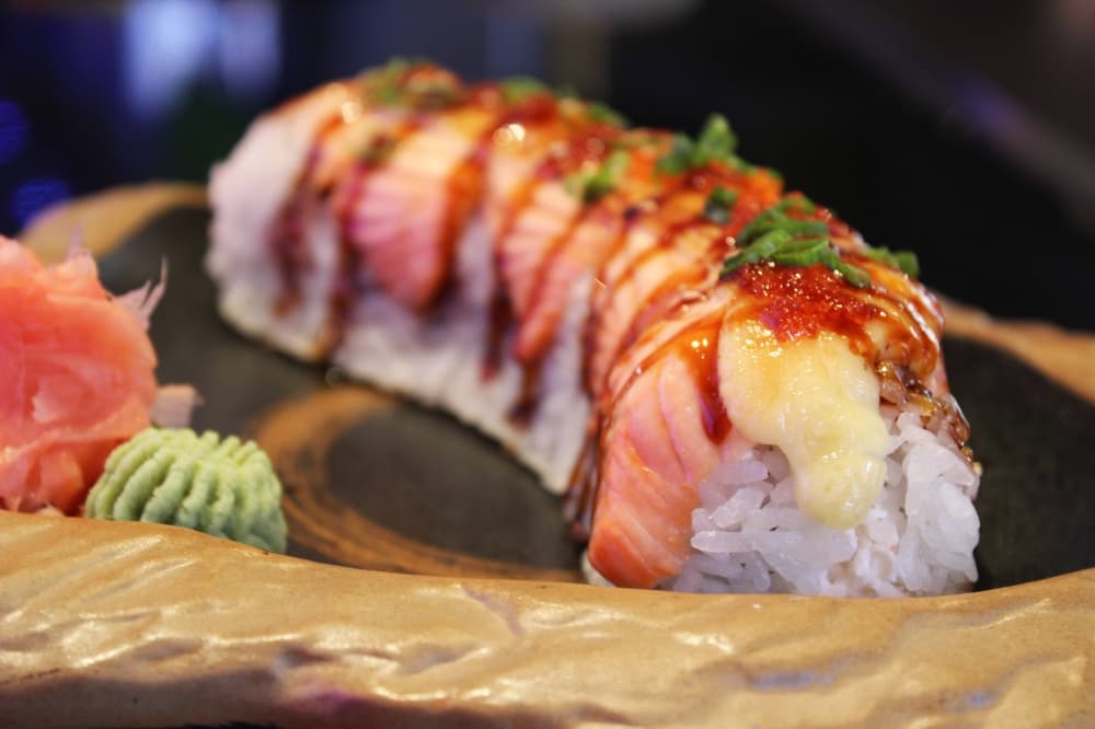 The Mountain Roll ($18.95) is a California roll topped with baked premium Norwegian salmon and includes eel sauce, masago and green onions. (Karen Chaney/Community Impact)
