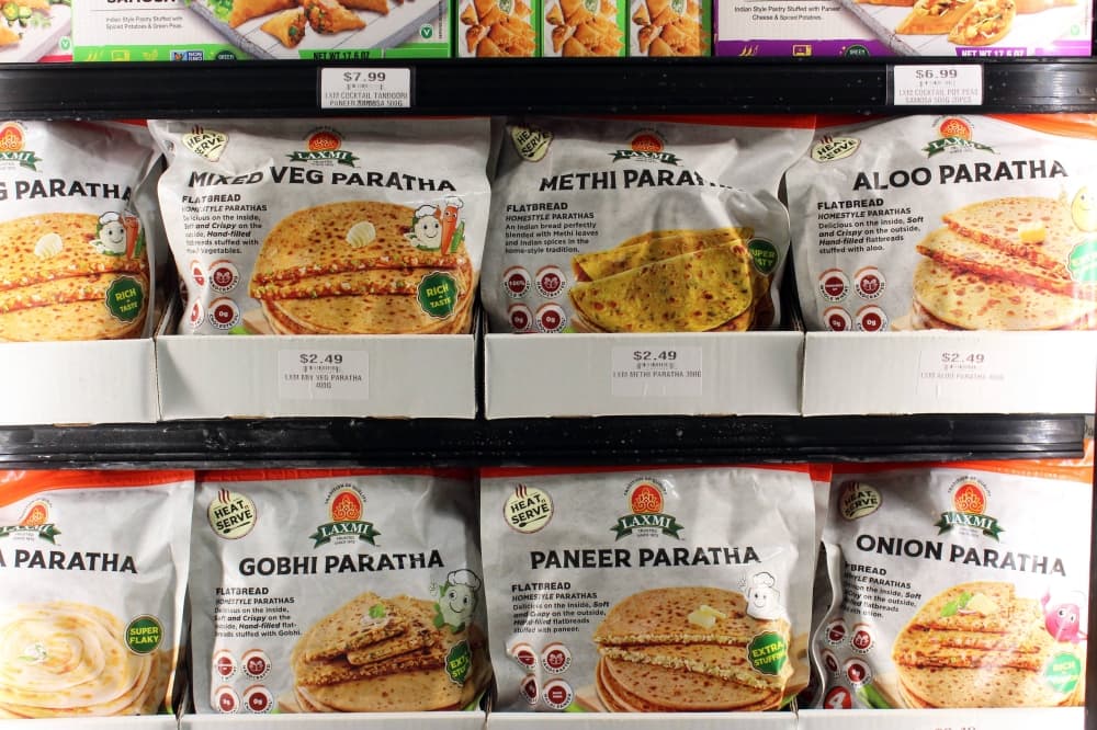 Bags of frozen food items on freezer shelves. 