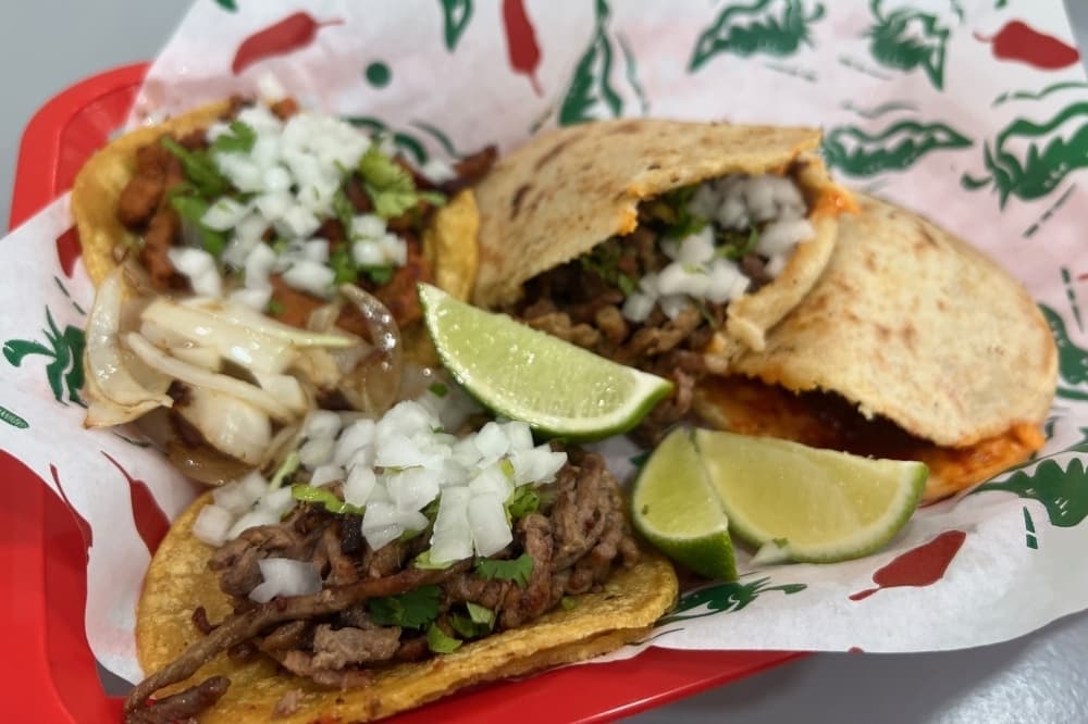 Beef tacos topped with onions and limes. 