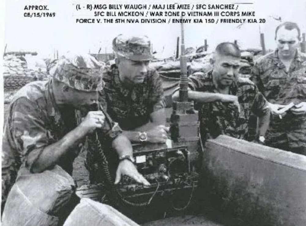 A black and white photo of a young Waugh is shown with other members of the army in the field.
