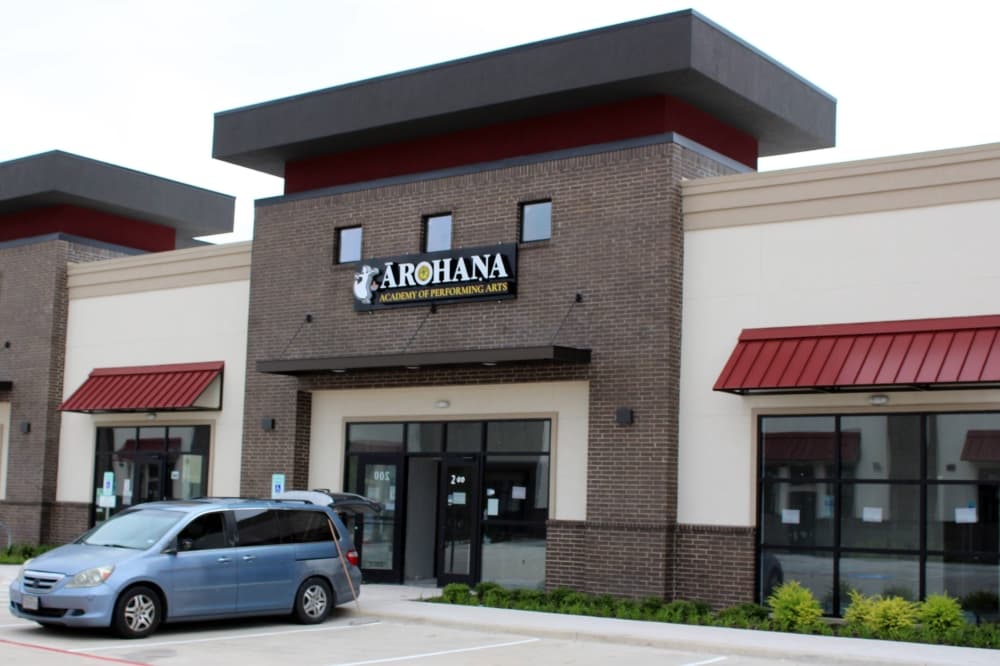 Exterior of strip mall with Arohana Academy of Performing Arts signage. 