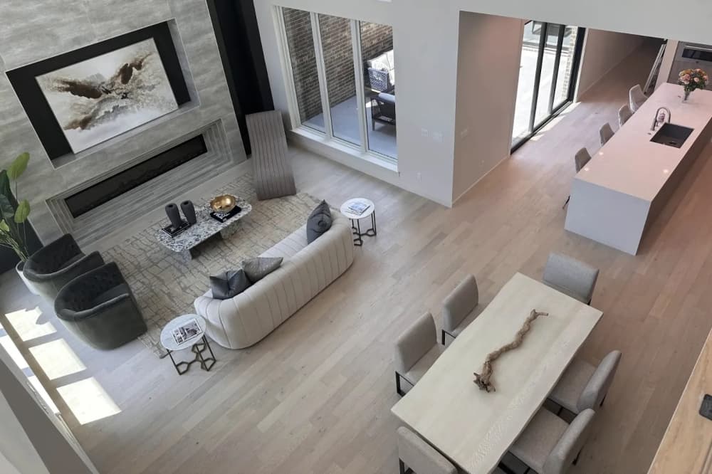 An aerial view of a townhome living room and dining area with three couches