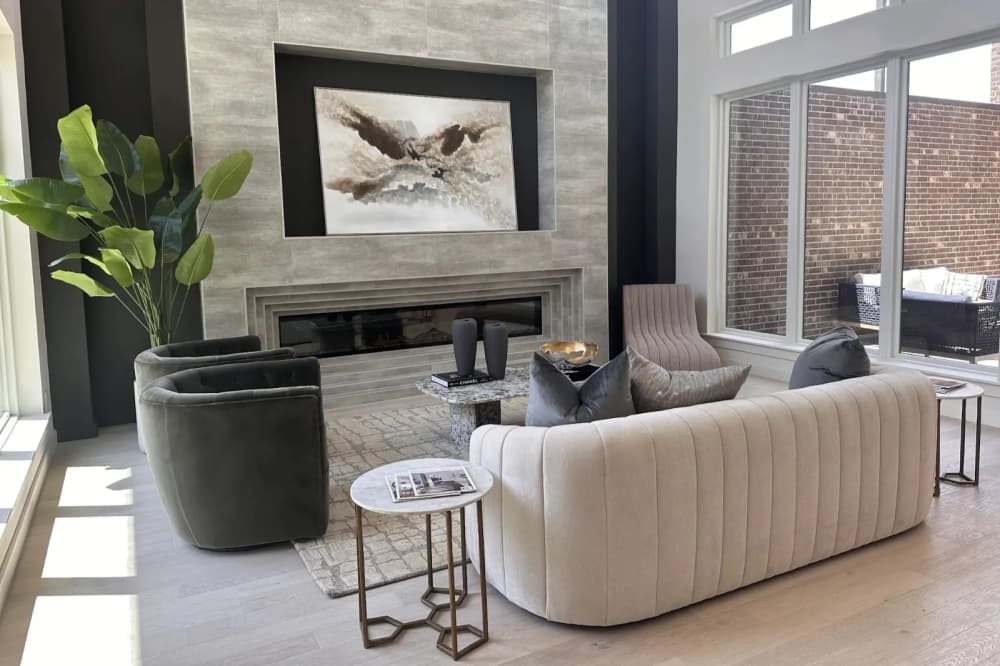 A living room area of a townhouse with three couches and a picture frame