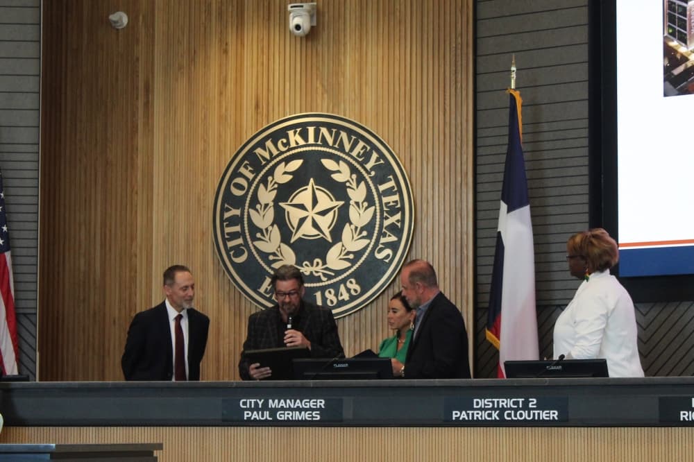 Outgoing Mayor George Fuller reads a certificate commemorating council member Ernest Lynch's election to McKinney City Council during a ceremony held June 17 at McKinney City Hall. (Colby Farr/Community Impact)
