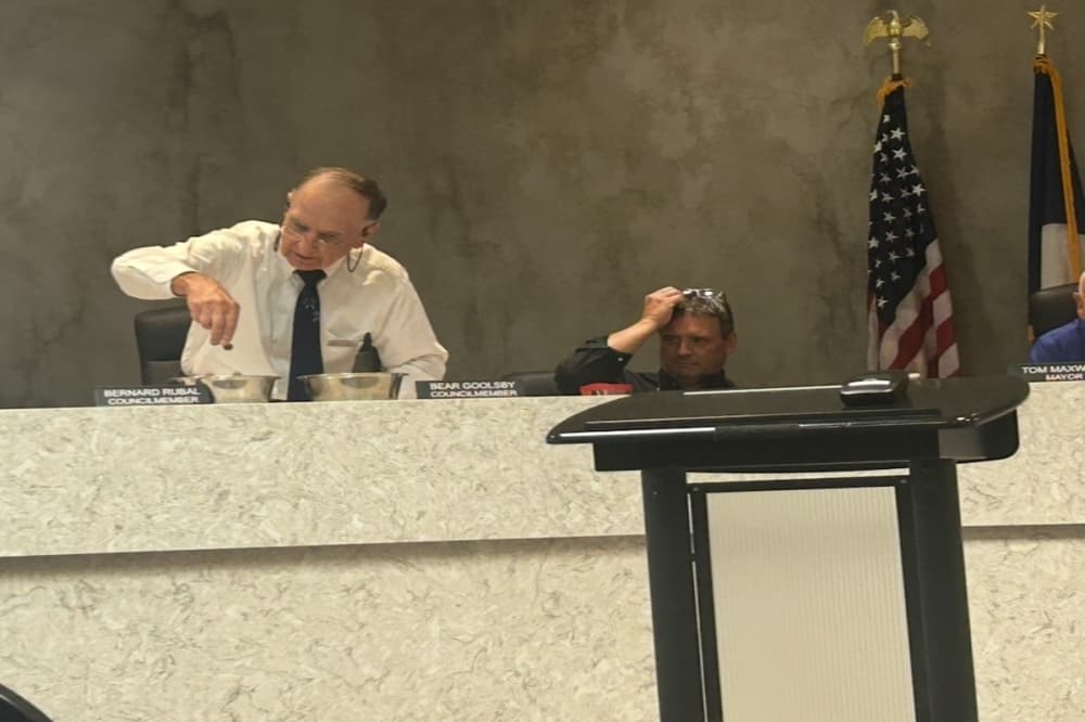 Council member Bernard Rubal dropped a penny into a pan for each time the word "estimated" was mentioned in the National Golf Foundation report. (Thomas Leffler/Community Impact)