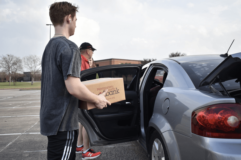 people loading things into a car 