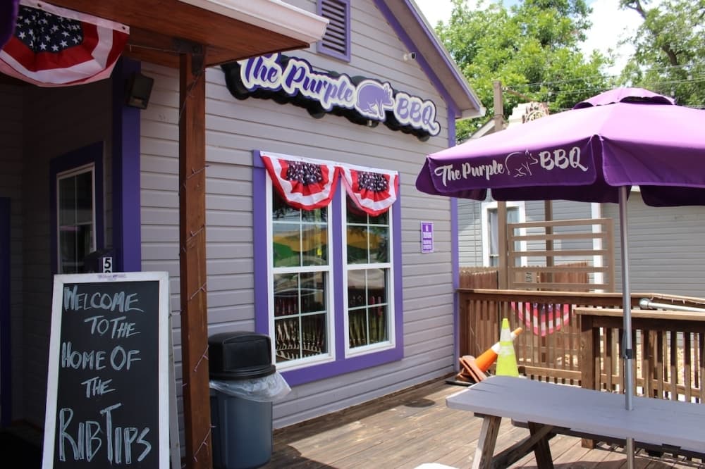 A purple restaurant with plenty of sun-filled outdoor seating.