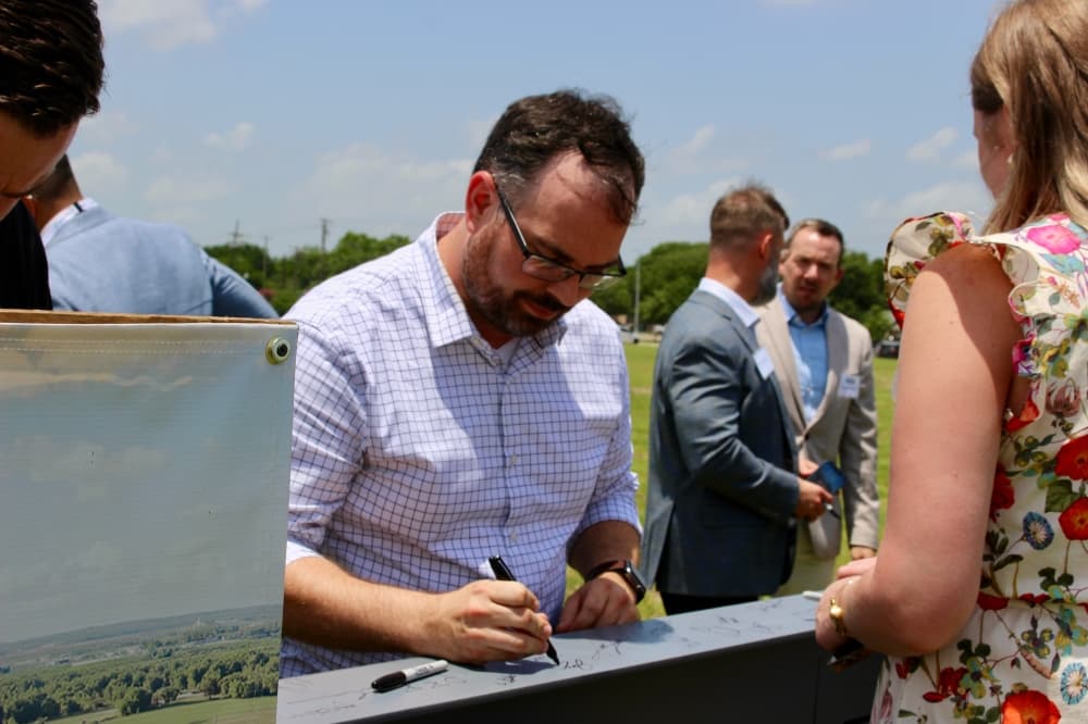 Encore Wire staff signing a commemorative beam