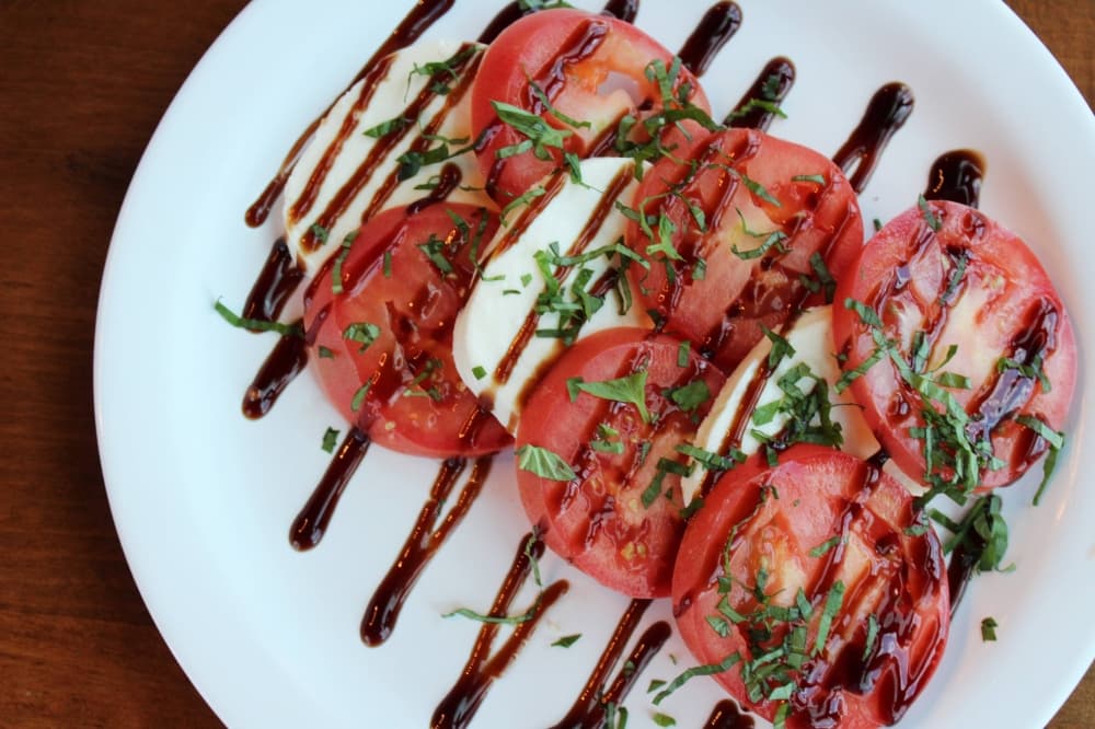 Tomatoes and mozzarella cheese drizzled with balsamic dressing. 