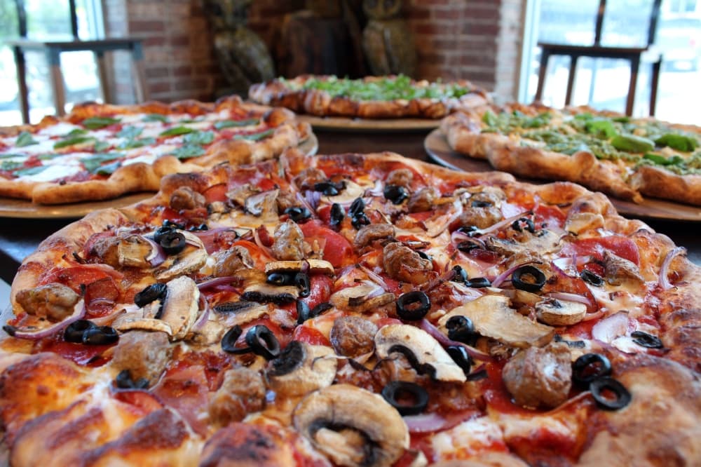 Pizza topped with sausage, olives, onions and more. 
