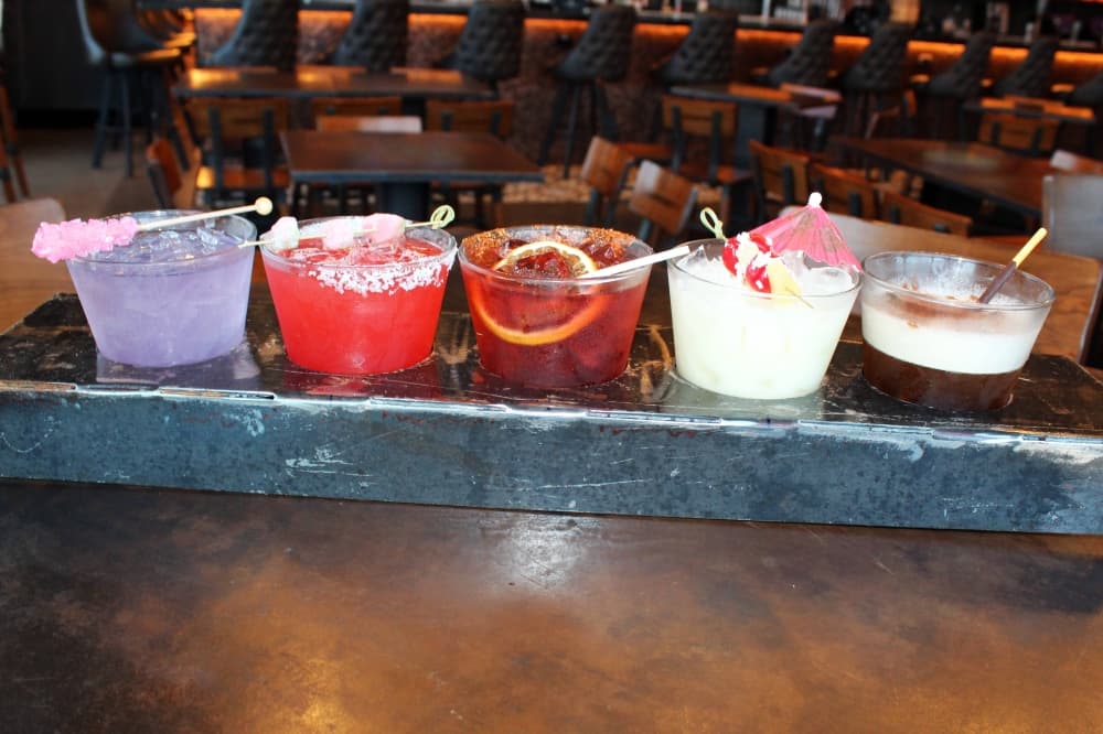 Five cocktails in a custom metal holder.