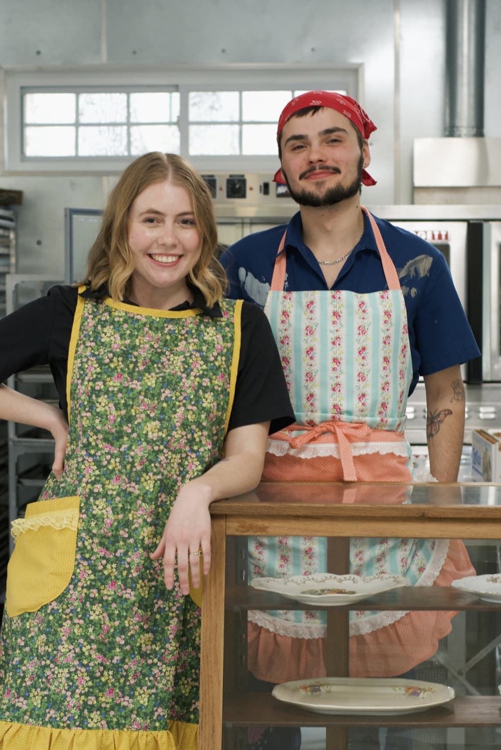 woman and man standing in aprons 
