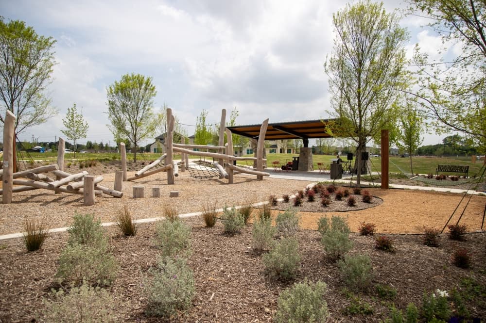 a natural park with wooden play structures and plants