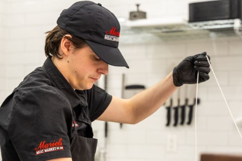An employee at Mariel's Meat Market prepares a cut of meat. (Courtesy Mariel's Meat Market)