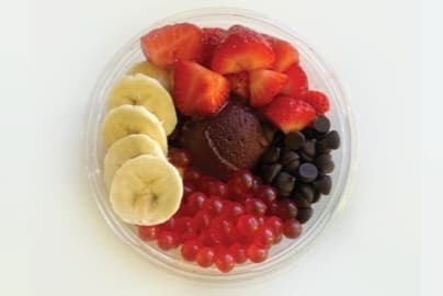An açaí bowl with banana, strawberries, chocolate chips, and popping boba.