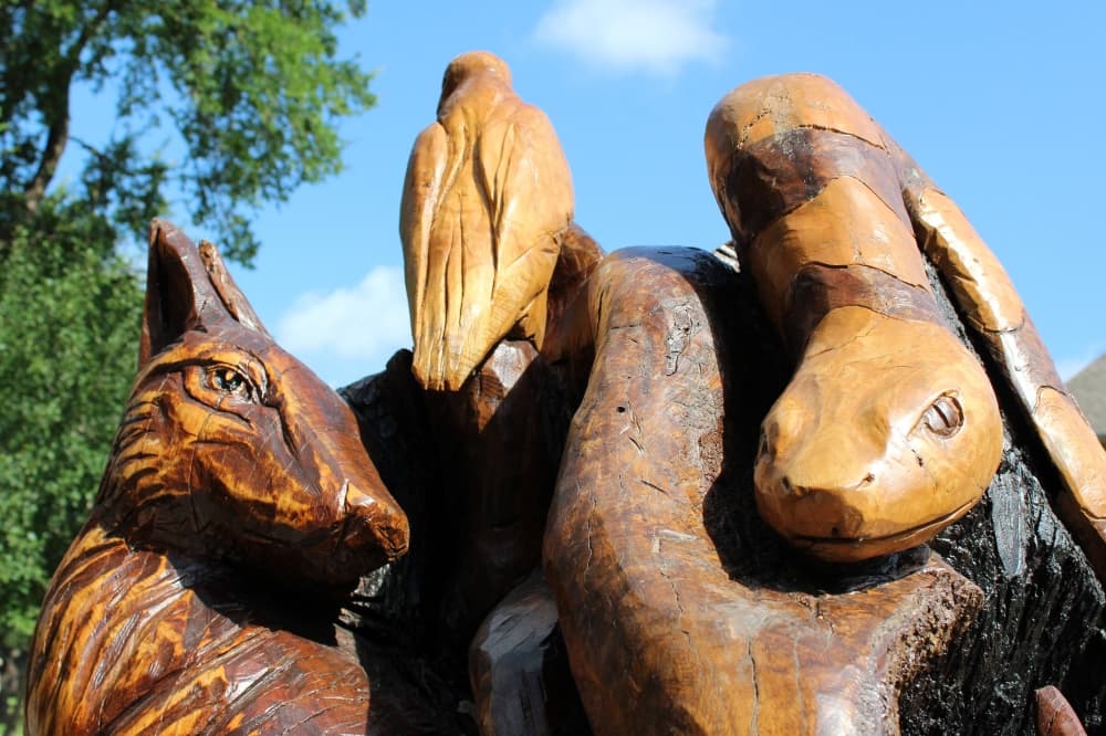 Wooden snake carved into a larger wood sculpture. 