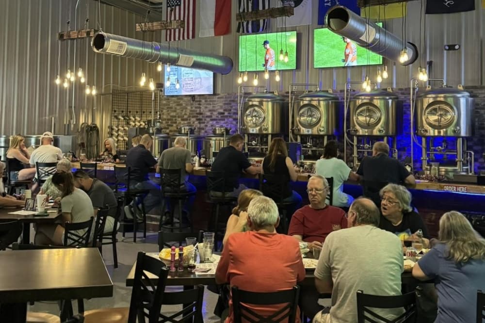 people sit in a restaurant with tvs