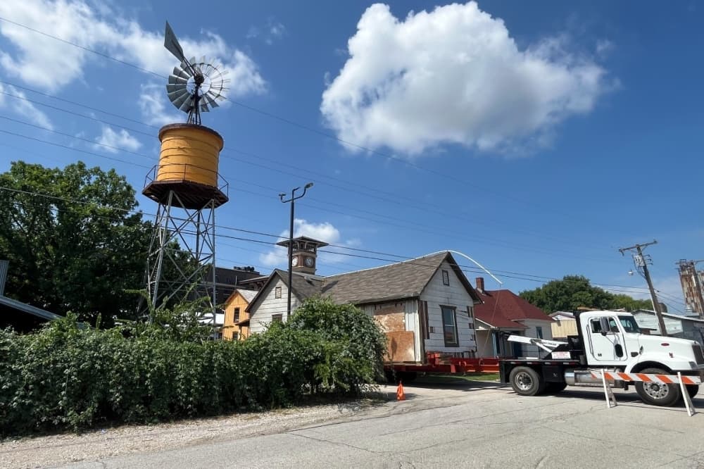 truck holding up a house 