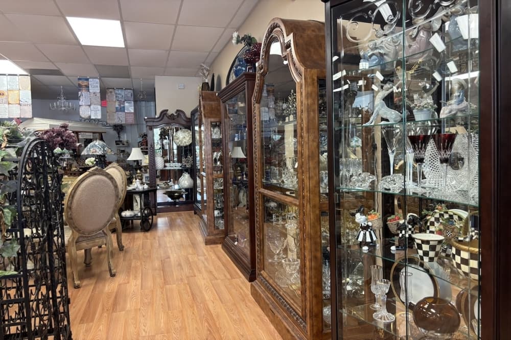 A row of antique wooden cabinets filled with crystal dish and glassware.