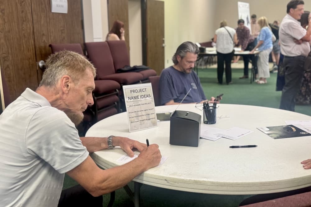 a man writes at a table