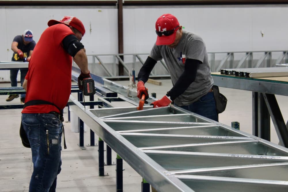 Steel panel being assembled by two men