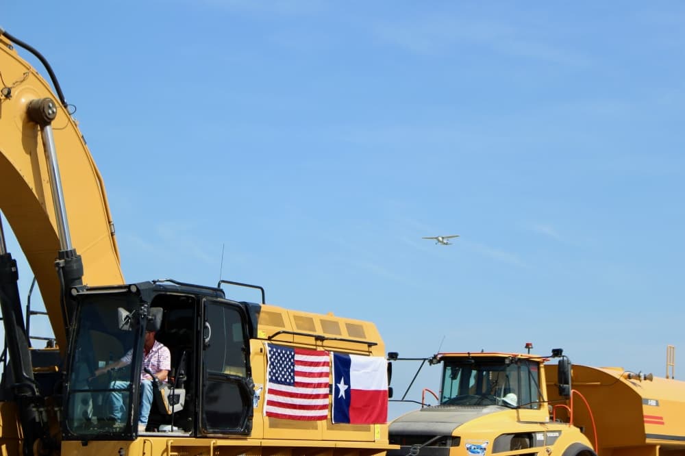 Plane flying over construction equipment