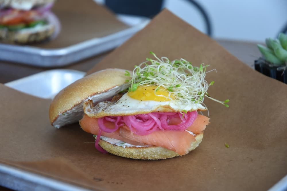 Image shows a bagel sandwich on a platter. 