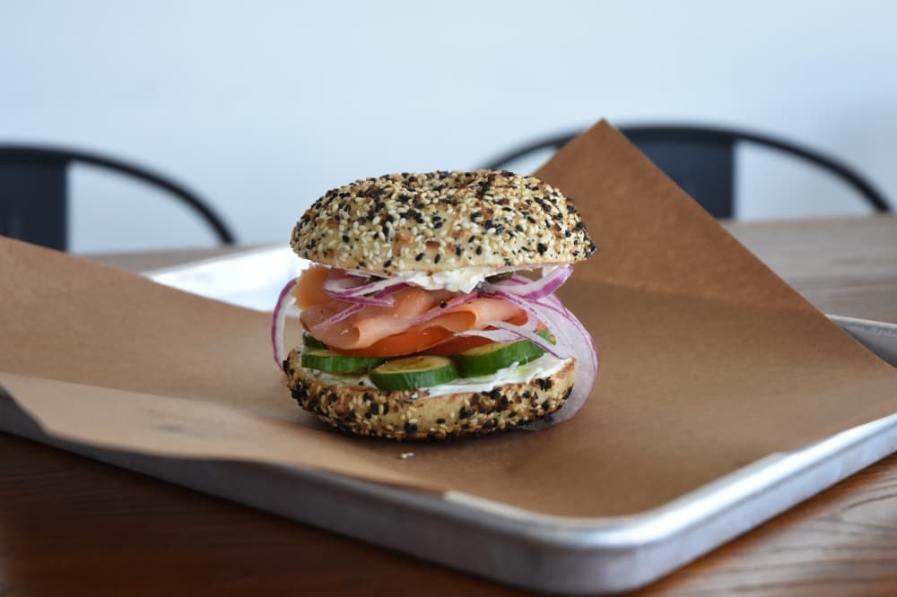 Image shows a bagel on a platter. 
