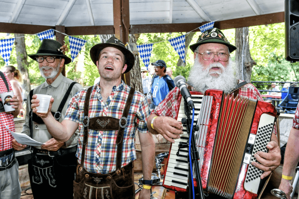 men dressed in German attire play instruments