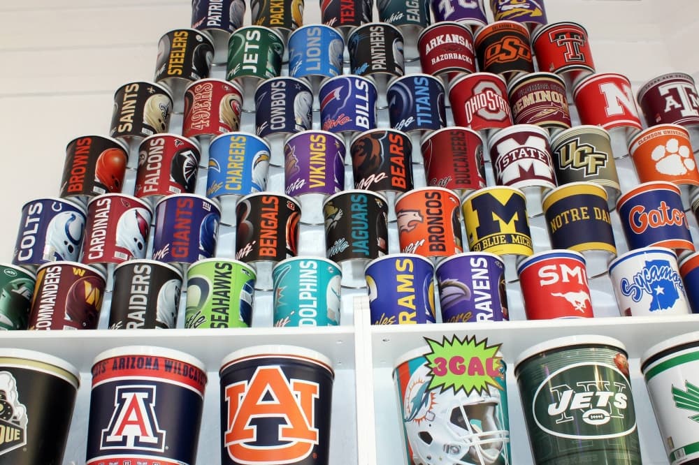 Tins featuring different sports logos stacked on top of each other against a wall. 