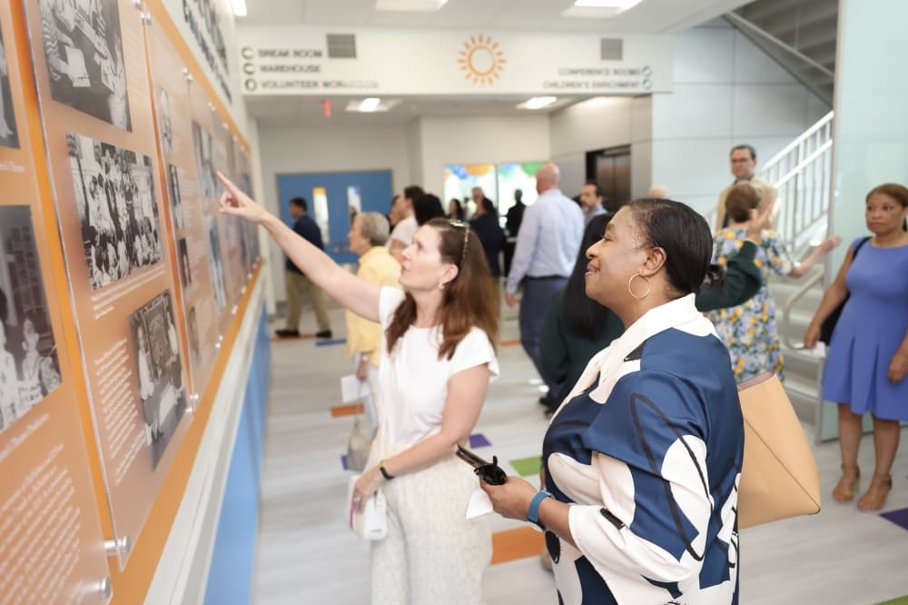 people point at a photo wall