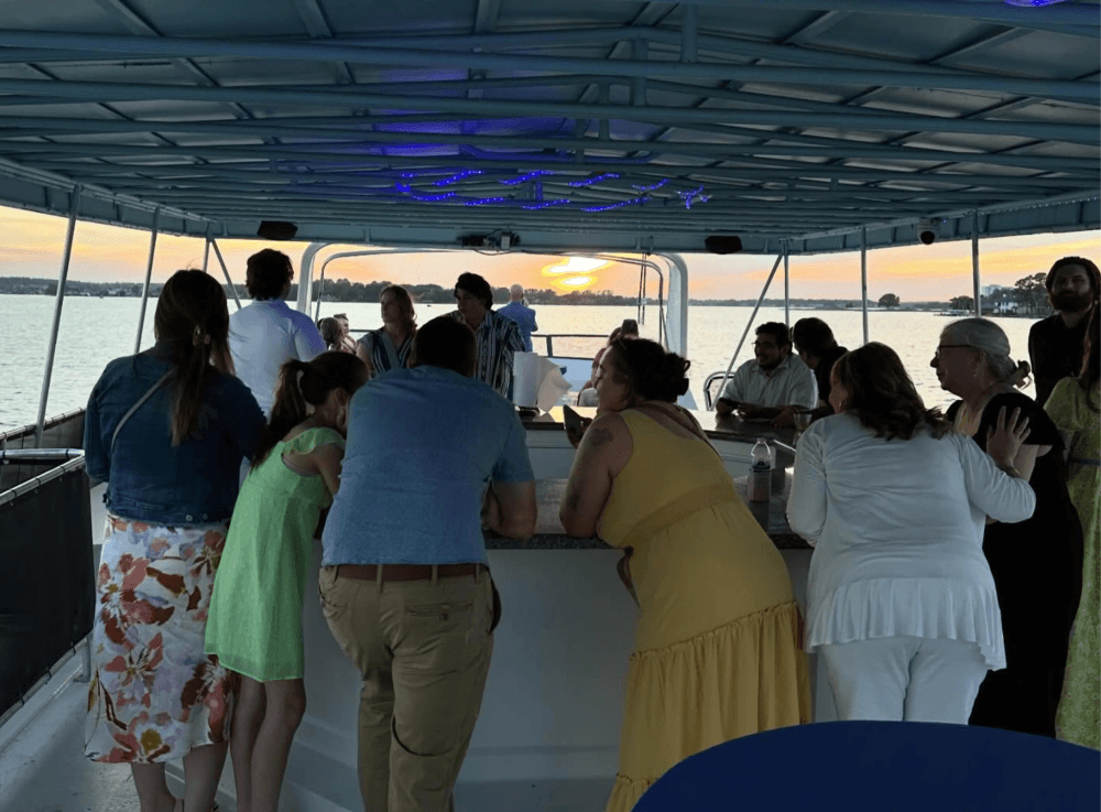 Guests enjoying the top deck of a luxury party yacht rental from Little Palm Cruises on Lake Conroe.