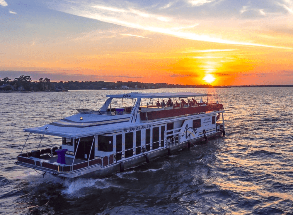 Lake Conroe yacht party hosted by Little Palm Cruises, featuring catered food and stunning sunset lakefront backdrops.