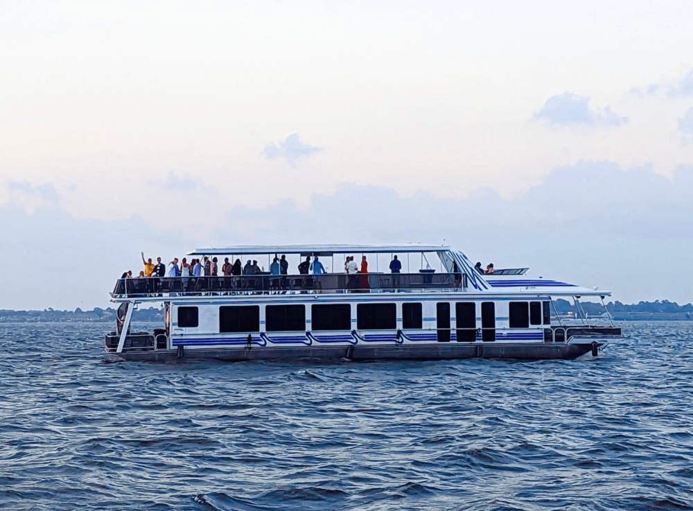 Little Palm Cruises boat cruising across Lake Conroe at sunset with scenic water views near Houston. 
