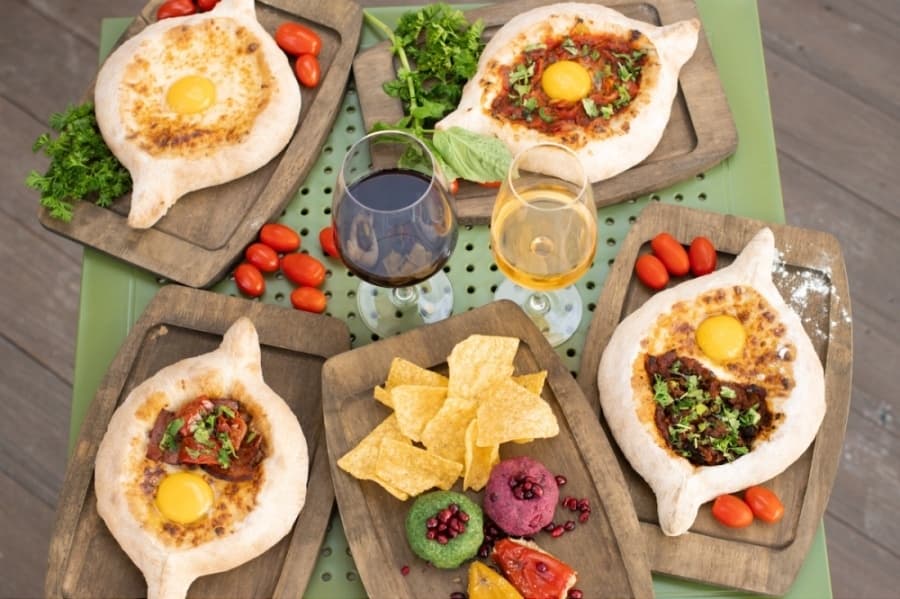 Image of bread boats on serving boards with glasses of wine 