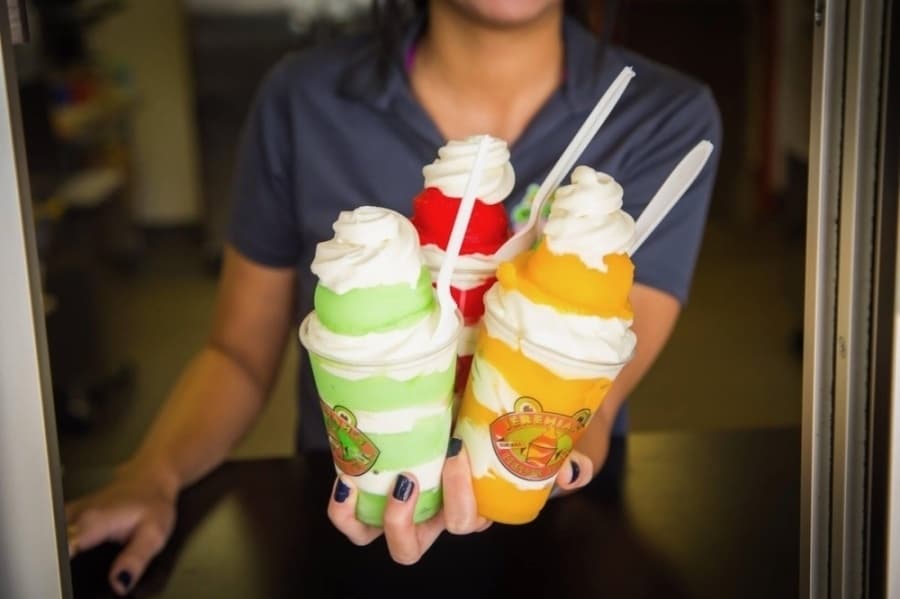 Image of worker holding three italian ice cups 